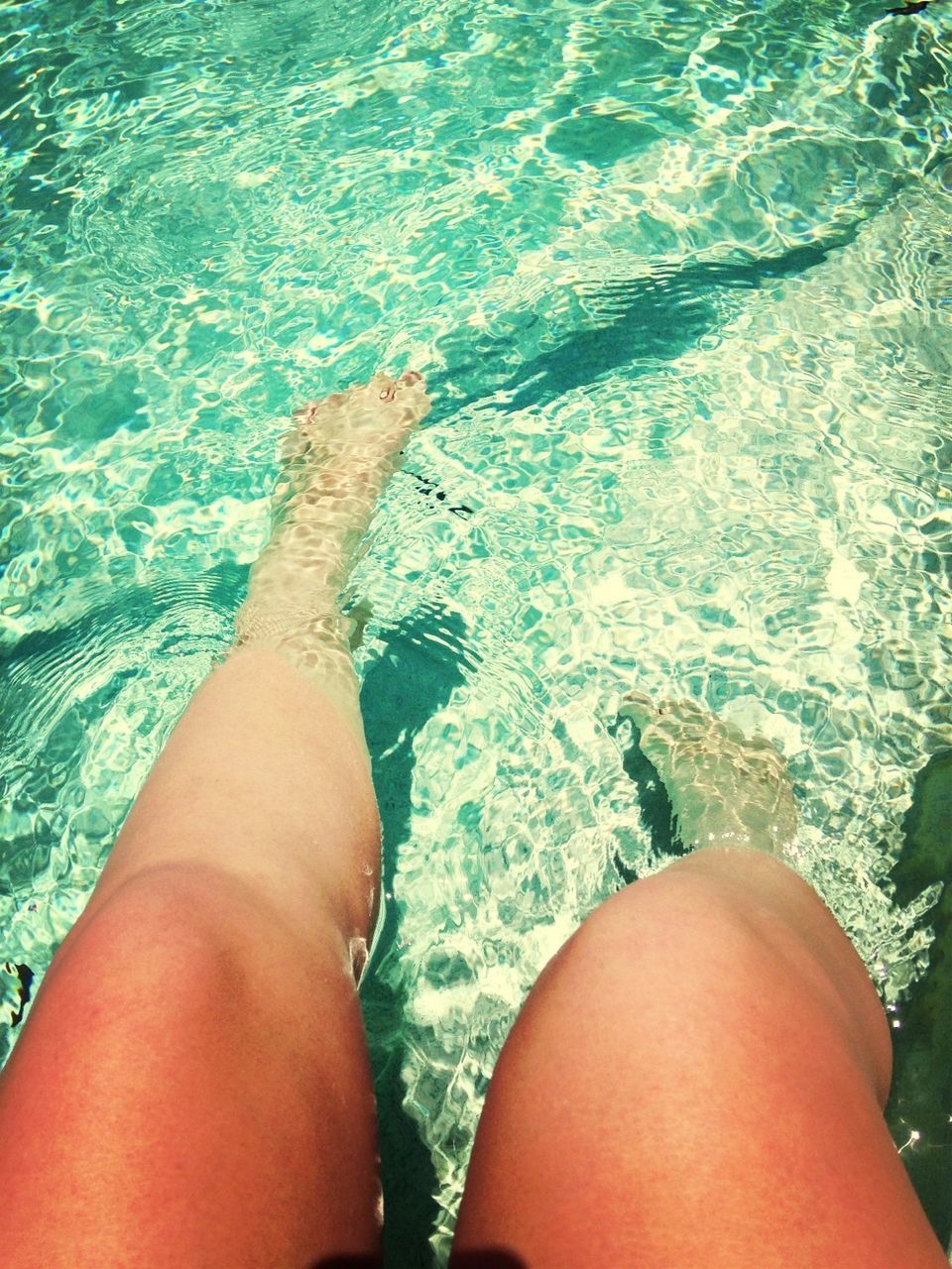 water, low section, person, personal perspective, lifestyles, leisure activity, barefoot, part of, human foot, sea, high angle view, vacations, swimming pool, unrecognizable person, relaxation, rippled