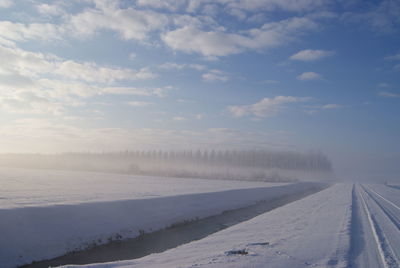 Snow covered landscape against sky