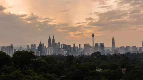 View of buildings in city against sky during sunset