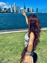 Rear view of woman looking at sea against sky