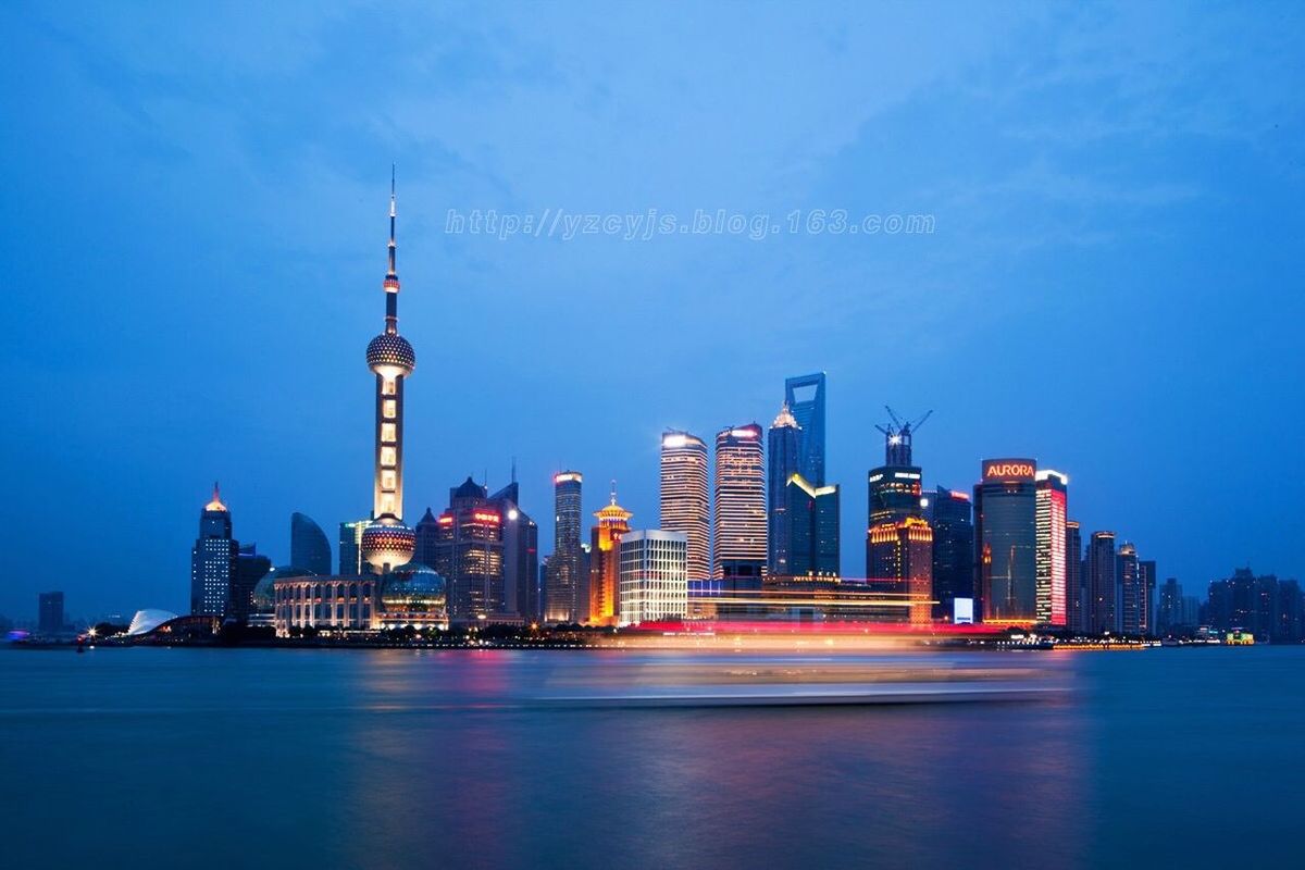 building exterior, architecture, skyscraper, city, built structure, tall - high, tower, waterfront, water, urban skyline, modern, cityscape, office building, financial district, capital cities, travel destinations, blue, famous place, illuminated, sea