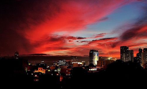 Illuminated cityscape against sky at night