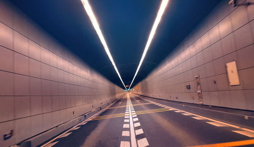 Low angle view of illuminated lights in tunnel