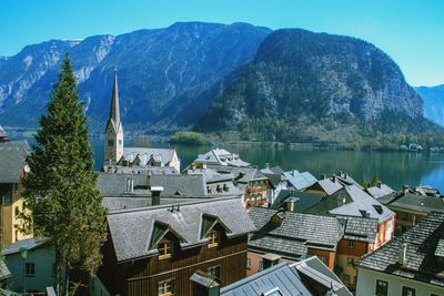 Houses by lake and buildings against sky