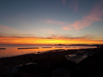 High angle view of silhouette buildings against sky during sunset