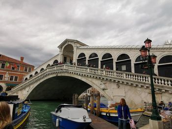 Bridge over canal against cloudy sky