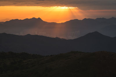 Scenic view of silhouette mountains against sky during sunset