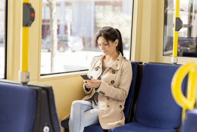 Woman using cellphone in tram