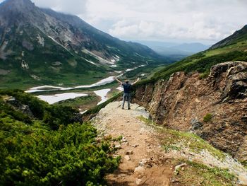 Rear view of person on mountain against sky