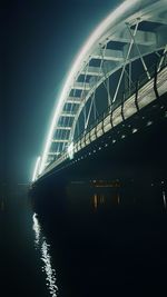 View of bridge over river at night