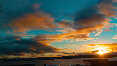 Scenic view of mountains against cloudy sky at sunset