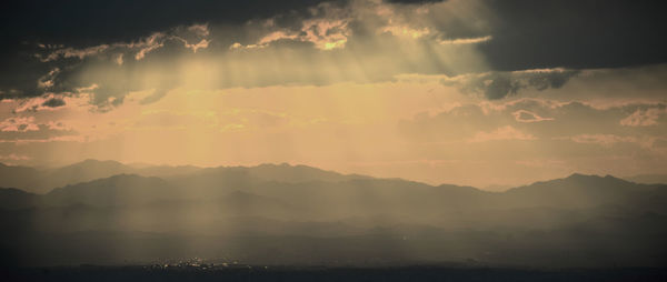 Scenic view of silhouette mountains against sky at sunset