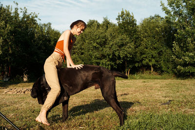 Side view of young man riding horse on field