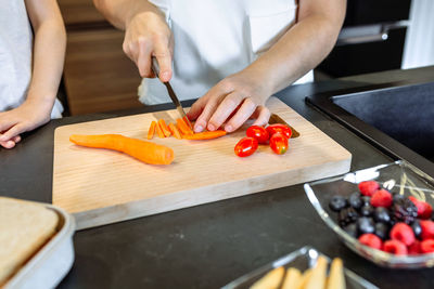 Midsection of man preparing food on cutting board