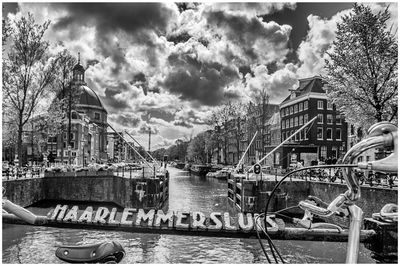 View of boats in river against cloudy sky