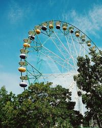 Low angle view of ferris wheel against blue sky