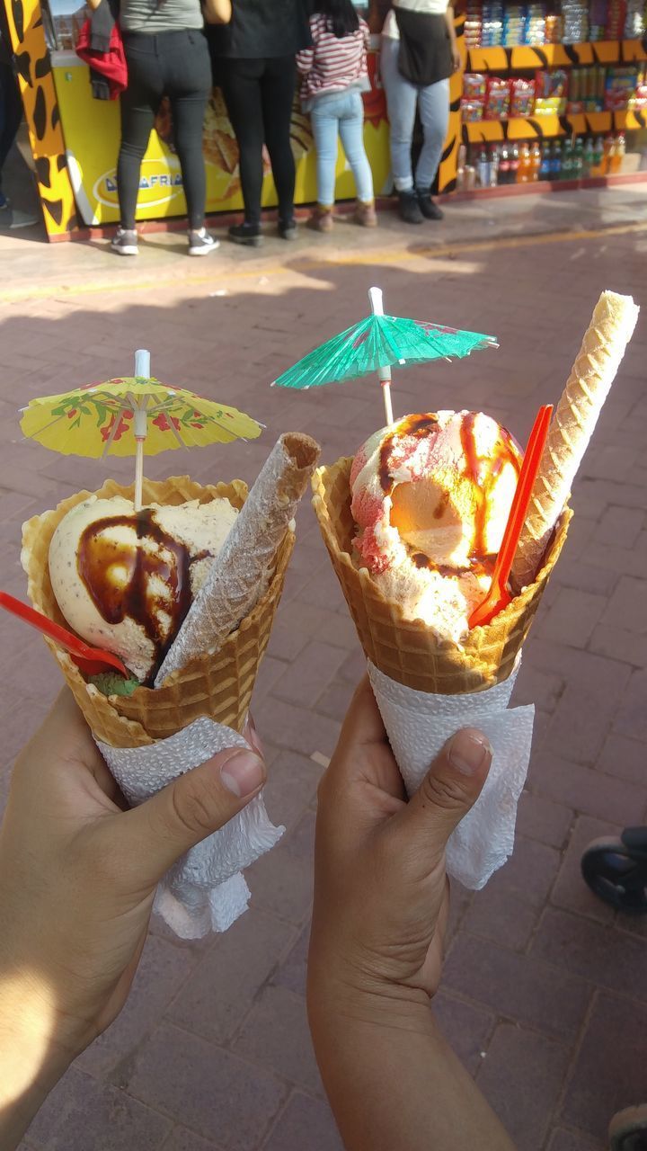 LOW SECTION OF PERSON HOLDING ICE CREAM