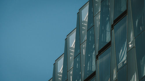 Low angle view of modern building against clear blue sky