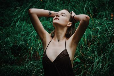 Young woman lying on grass in field