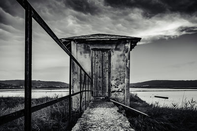 Built structure on beach by sea against sky