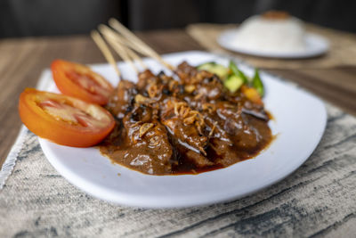 Sate ayam, satays with peanut sauce, famous indonesian cuisine photographed with high angle view