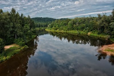 Scenic view of lake by trees against sky