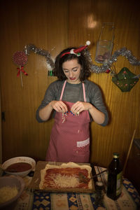 Full length of woman holding drink on table