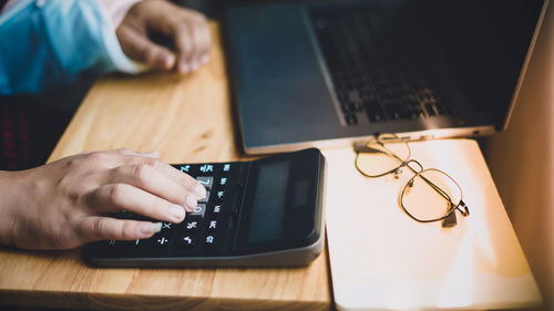 Midsection of woman using laptop on table