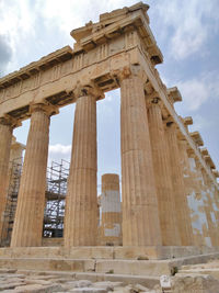 Low angle view of historical building against cloudy sky