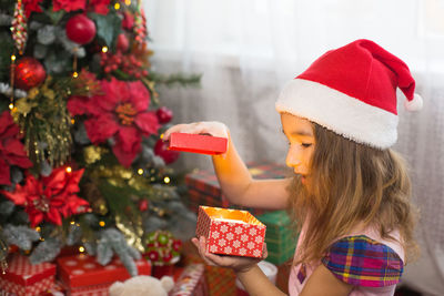 Girl holding christmas tree in box