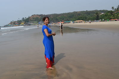 Woman holding umbrella on beach
