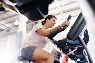 Low angle view of woman exercising at gym