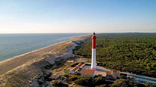 High angle view of lighthouse at beach against clear sky