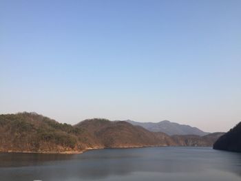 Scenic view of lake and mountains against clear sky