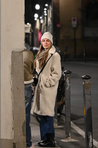 Portrait of young woman standing in city