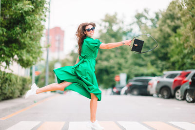 Side view of woman with umbrella on road