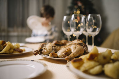 Food and wine glasses on table with boy in background