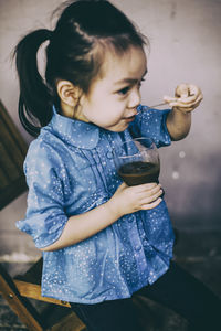 High angle view of cute girl drinking from spoon