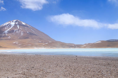 Scenic view of sea and mountains against blue sky