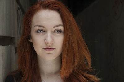 Headshot of young redhead woman amidst alley