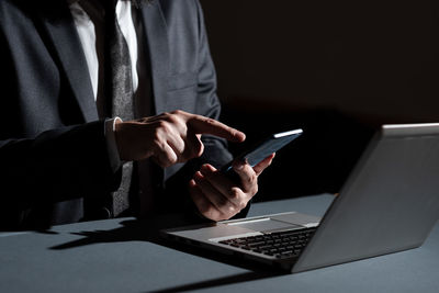 Midsection of businessman using mobile phone