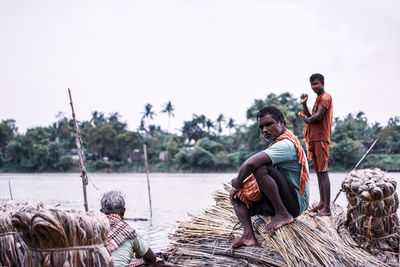 People sitting on land against clear sky