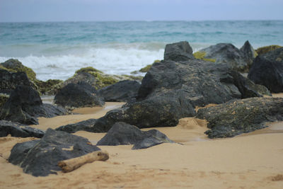 Rocks on beach against sky