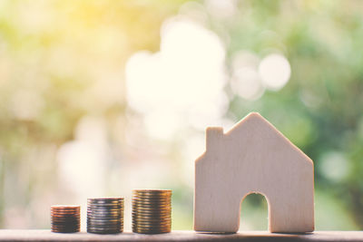 Close-up of stacked coins by model house