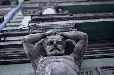 Low angle view of angel statue against old building