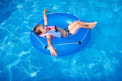 High angle view of boy relaxing in swimming pool