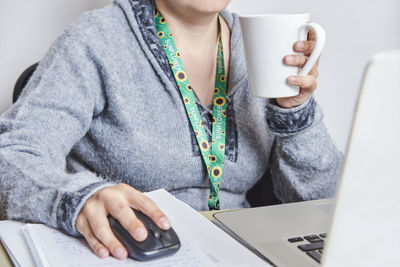 Midsection of woman using mobile phone while sitting at home