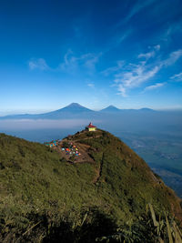 Panoramic view of landscape and mountains against blue sky