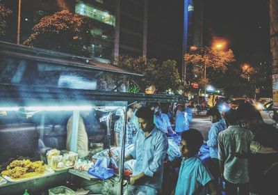 People in illuminated market at night