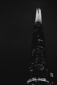 Low angle view of illuminated buildings against sky at night